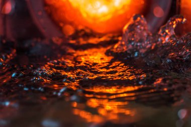 Bir volkanın lavında denizin taklidi, suyun dokusu kırmızı ışıkta çıkan hava kabarcıklarıyla kaos yaratıyor.