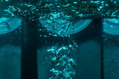 Suyun dokusu, hava kabarcıklarının oluşturduğu gürleyen bir kaostur. Mavi ışıkta dışarıya doğru kaçıyorlar.