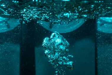 Suyun dokusu, hava kabarcıklarının oluşturduğu gürleyen bir kaostur. Mavi ışıkta dışarıya doğru kaçıyorlar.