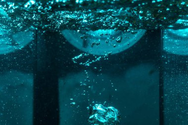 Suyun dokusu, hava kabarcıklarının oluşturduğu gürleyen bir kaostur. Mavi ışıkta dışarıya doğru kaçıyorlar.