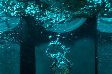 Suyun dokusu, hava kabarcıklarının oluşturduğu gürleyen bir kaostur. Mavi ışıkta dışarıya doğru kaçıyorlar.