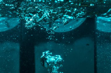 Suyun dokusu, hava kabarcıklarının oluşturduğu gürleyen bir kaostur. Mavi ışıkta dışarıya doğru kaçıyorlar.