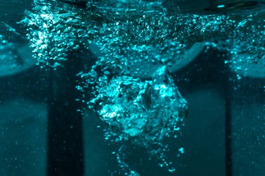 Suyun dokusu, hava kabarcıklarının oluşturduğu gürleyen bir kaostur. Mavi ışıkta dışarıya doğru kaçıyorlar.