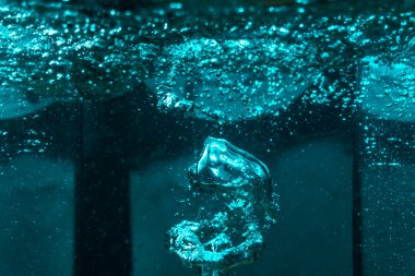 Suyun dokusu, hava kabarcıklarının oluşturduğu gürleyen bir kaostur. Mavi ışıkta dışarıya doğru kaçıyorlar.