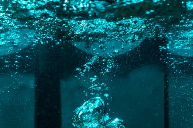 Suyun dokusu, hava kabarcıklarının oluşturduğu gürleyen bir kaostur. Mavi ışıkta dışarıya doğru kaçıyorlar.