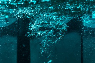 Suyun dokusu, hava kabarcıklarının oluşturduğu gürleyen bir kaostur. Mavi ışıkta dışarıya doğru kaçıyorlar.