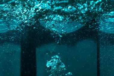 Suyun dokusu, hava kabarcıklarının oluşturduğu gürleyen bir kaostur. Mavi ışıkta dışarıya doğru kaçıyorlar.