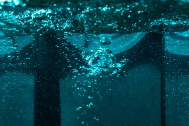 Suyun dokusu, hava kabarcıklarının oluşturduğu gürleyen bir kaostur. Mavi ışıkta dışarıya doğru kaçıyorlar.