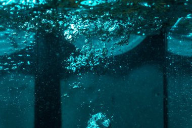 Suyun dokusu, hava kabarcıklarının oluşturduğu gürleyen bir kaostur. Mavi ışıkta dışarıya doğru kaçıyorlar.