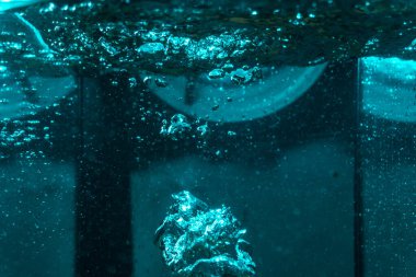 Suyun dokusu, hava kabarcıklarının oluşturduğu gürleyen bir kaostur. Mavi ışıkta dışarıya doğru kaçıyorlar.