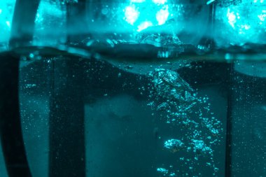 Suyun dokusu, hava kabarcıklarının oluşturduğu gürleyen bir kaostur. Mavi ışıkta dışarıya doğru kaçıyorlar.