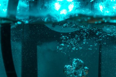 Suyun dokusu, hava kabarcıklarının oluşturduğu gürleyen bir kaostur. Mavi ışıkta dışarıya doğru kaçıyorlar.