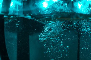 Suyun dokusu, hava kabarcıklarının oluşturduğu gürleyen bir kaostur. Mavi ışıkta dışarıya doğru kaçıyorlar.