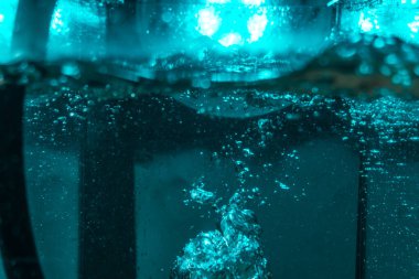 Suyun dokusu, hava kabarcıklarının oluşturduğu gürleyen bir kaostur. Mavi ışıkta dışarıya doğru kaçıyorlar.