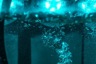 Suyun dokusu, hava kabarcıklarının oluşturduğu gürleyen bir kaostur. Mavi ışıkta dışarıya doğru kaçıyorlar.