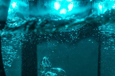 Suyun dokusu, hava kabarcıklarının oluşturduğu gürleyen bir kaostur. Mavi ışıkta dışarıya doğru kaçıyorlar.