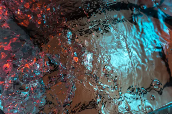 Su dokusu gürleyen kaos içinde hava kabarcıkları yaratıyor mavi ve kırmızı ışıkta dışarı kaçıyorlar.