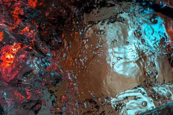 Su dokusu gürleyen kaos içinde hava kabarcıkları yaratıyor mavi ve kırmızı ışıkta dışarı kaçıyorlar.