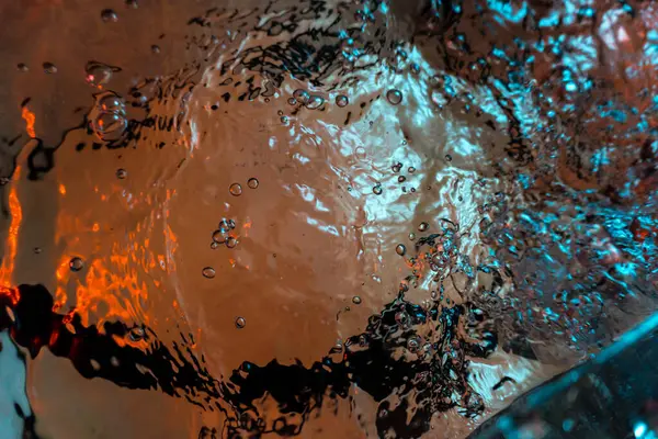 Su dokusu gürleyen kaos içinde hava kabarcıkları yaratıyor mavi ve kırmızı ışıkta dışarı kaçıyorlar.