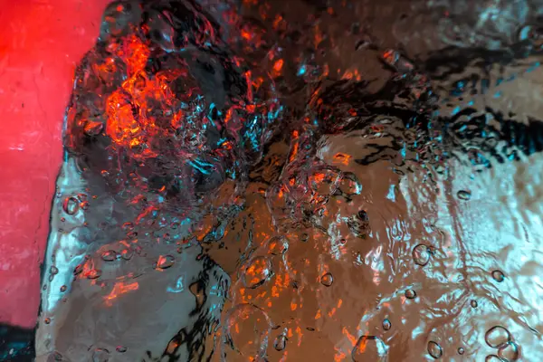 Su dokusu gürleyen kaos içinde hava kabarcıkları yaratıyor mavi ve kırmızı ışıkta dışarı kaçıyorlar.