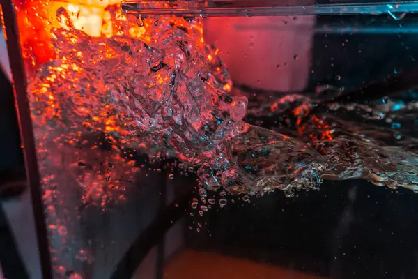 Bir volkanın lavında denizin taklidi, suyun dokusu kırmızı ışıkta çıkan hava kabarcıklarıyla kaos yaratıyor.