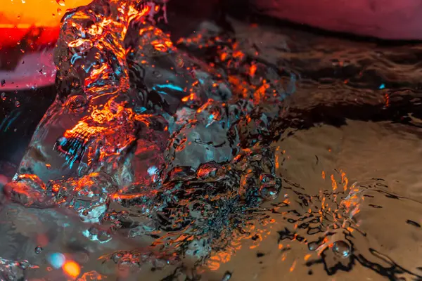 Bir volkanın lavında denizin taklidi, suyun dokusu kırmızı ışıkta çıkan hava kabarcıklarıyla kaos yaratıyor.