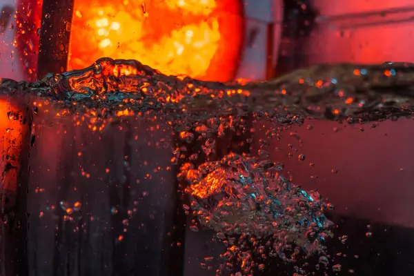 Bir volkanın lavında denizin taklidi, suyun dokusu kırmızı ışıkta çıkan hava kabarcıklarıyla kaos yaratıyor.