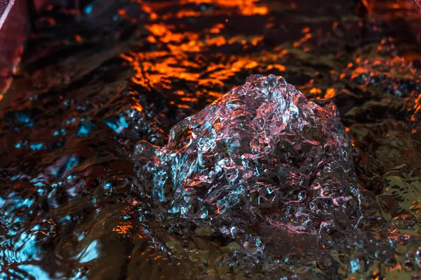 Bir volkanın lavında denizin taklidi, suyun dokusu kırmızı ışıkta çıkan hava kabarcıklarıyla kaos yaratıyor.