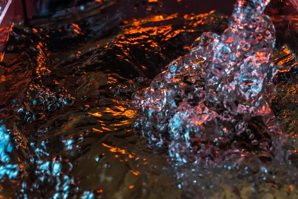 Bir volkanın lavında denizin taklidi, suyun dokusu kırmızı ışıkta çıkan hava kabarcıklarıyla kaos yaratıyor.