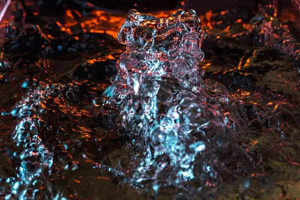 Bir volkanın lavında denizin taklidi, suyun dokusu kırmızı ışıkta çıkan hava kabarcıklarıyla kaos yaratıyor.