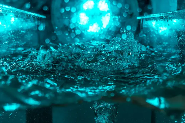 Suyun dokusu, hava kabarcıklarının oluşturduğu gürleyen bir kaostur. Mavi ışıkta dışarıya doğru kaçıyorlar.