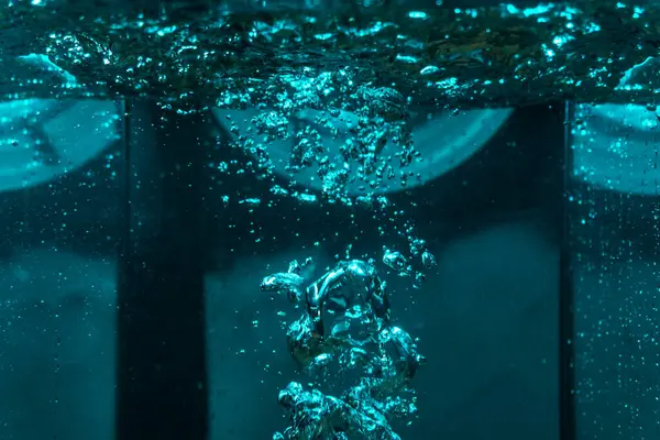 Suyun dokusu, hava kabarcıklarının oluşturduğu gürleyen bir kaostur. Mavi ışıkta dışarıya doğru kaçıyorlar.