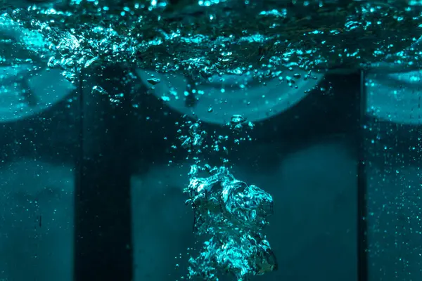 Suyun dokusu, hava kabarcıklarının oluşturduğu gürleyen bir kaostur. Mavi ışıkta dışarıya doğru kaçıyorlar.