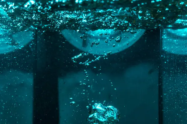 Suyun dokusu, hava kabarcıklarının oluşturduğu gürleyen bir kaostur. Mavi ışıkta dışarıya doğru kaçıyorlar.