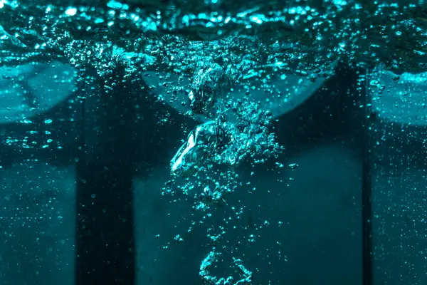 Suyun dokusu, hava kabarcıklarının oluşturduğu gürleyen bir kaostur. Mavi ışıkta dışarıya doğru kaçıyorlar.