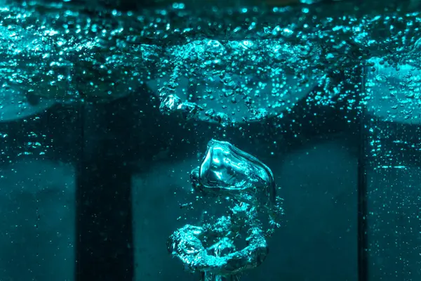 Suyun dokusu, hava kabarcıklarının oluşturduğu gürleyen bir kaostur. Mavi ışıkta dışarıya doğru kaçıyorlar.