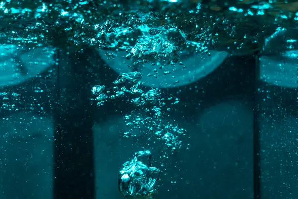 Suyun dokusu, hava kabarcıklarının oluşturduğu gürleyen bir kaostur. Mavi ışıkta dışarıya doğru kaçıyorlar.