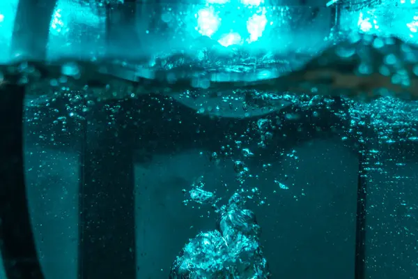 Suyun dokusu, hava kabarcıklarının oluşturduğu gürleyen bir kaostur. Mavi ışıkta dışarıya doğru kaçıyorlar.