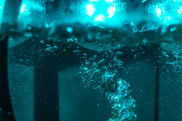 Suyun dokusu, hava kabarcıklarının oluşturduğu gürleyen bir kaostur. Mavi ışıkta dışarıya doğru kaçıyorlar.