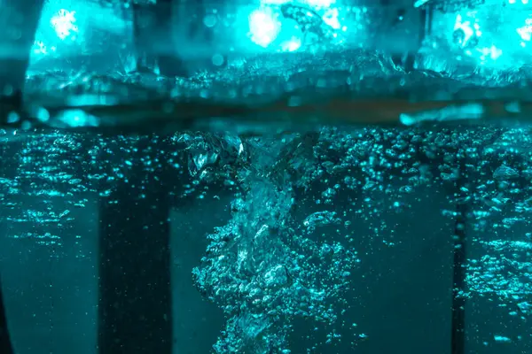 Suyun dokusu, hava kabarcıklarının oluşturduğu gürleyen bir kaostur. Mavi ışıkta dışarıya doğru kaçıyorlar.