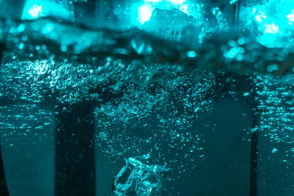 Suyun dokusu, hava kabarcıklarının oluşturduğu gürleyen bir kaostur. Mavi ışıkta dışarıya doğru kaçıyorlar.