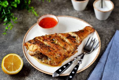 Bitki, sarımsak, limon suyu ve soya sosuyla pişirilmiş deniz balığı.