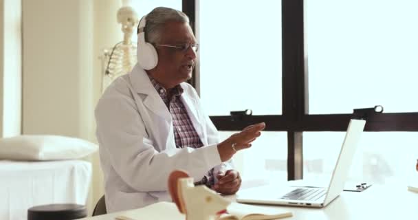 Απασχολημένος Ανώτερος Ιατρός Λευκό Παλτό Και Ασύρματα Ακουστικά Μιλώντας Βιντεοκλήση — Αρχείο Βίντεο