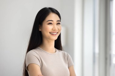 Mutlu, güzel, Asyalı bir kadının dişlek gülüşlü ev portresi. Olumlu, neşeli, düz, uzun siyah saçlı, pürüzsüz tenli, gülen bir Koreli kız.