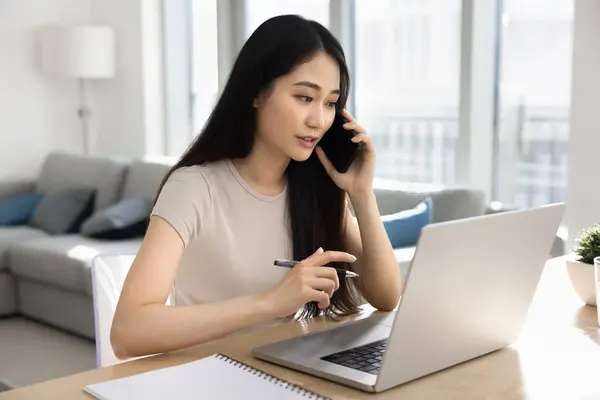 Allvarligt Upptagen Ung Asiatisk Affärskvinna Talar Mobiltelefon Laptop Arbetar Vid Royaltyfria Stockfoton