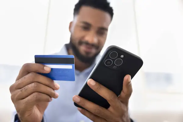 Позитивний Молодий Африканський Чоловік Тримає Блакитну Пластикову Кредитну Картку Мобільний — стокове фото
