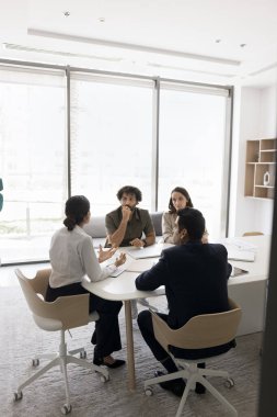 Toplantı masasında konuşan çok ırklı meslektaşlar, iş görüşmeleri, proje yönetimi, başlangıçta işbirliği yapmak, takım çalışması planlamak, genç bayan liderin konuşmasını dinlemek.