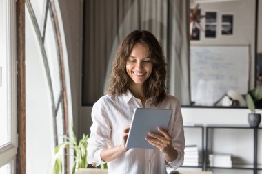 Tabletle proje üzerinde çalışan mutlu, genç profesyonel kadın, iş başvurusu, internet teknolojisi, iş iletişimi, daktilo, dokunmatik ekran, gülümseme, kahkaha