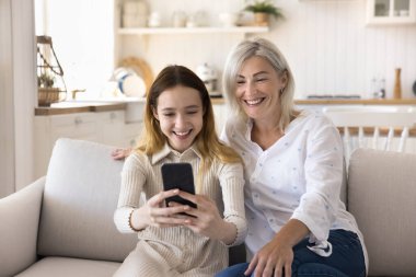 Ergenlik öncesi kızı olan mutlu bir anne evde vakit geçirir, video görüşmesi yapar, akıllı telefon kullanır, selfie çeker. İki kadın nesil ailesi kablosuz internet iletişiminin keyfini çıkarıyor. Boş zaman, modern teknoloji.