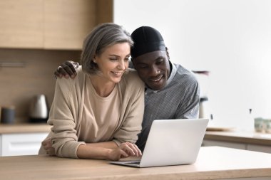 Kaygısız orta yaşlı eşler hafta sonunu evde geçirir, mutfak masasında durur, dizüstü bilgisayar kullanır, ekrana bakar, interneti okur, e-posta okur, internetten alışveriş yapar, alışverişi tartışır, sipariş verir.